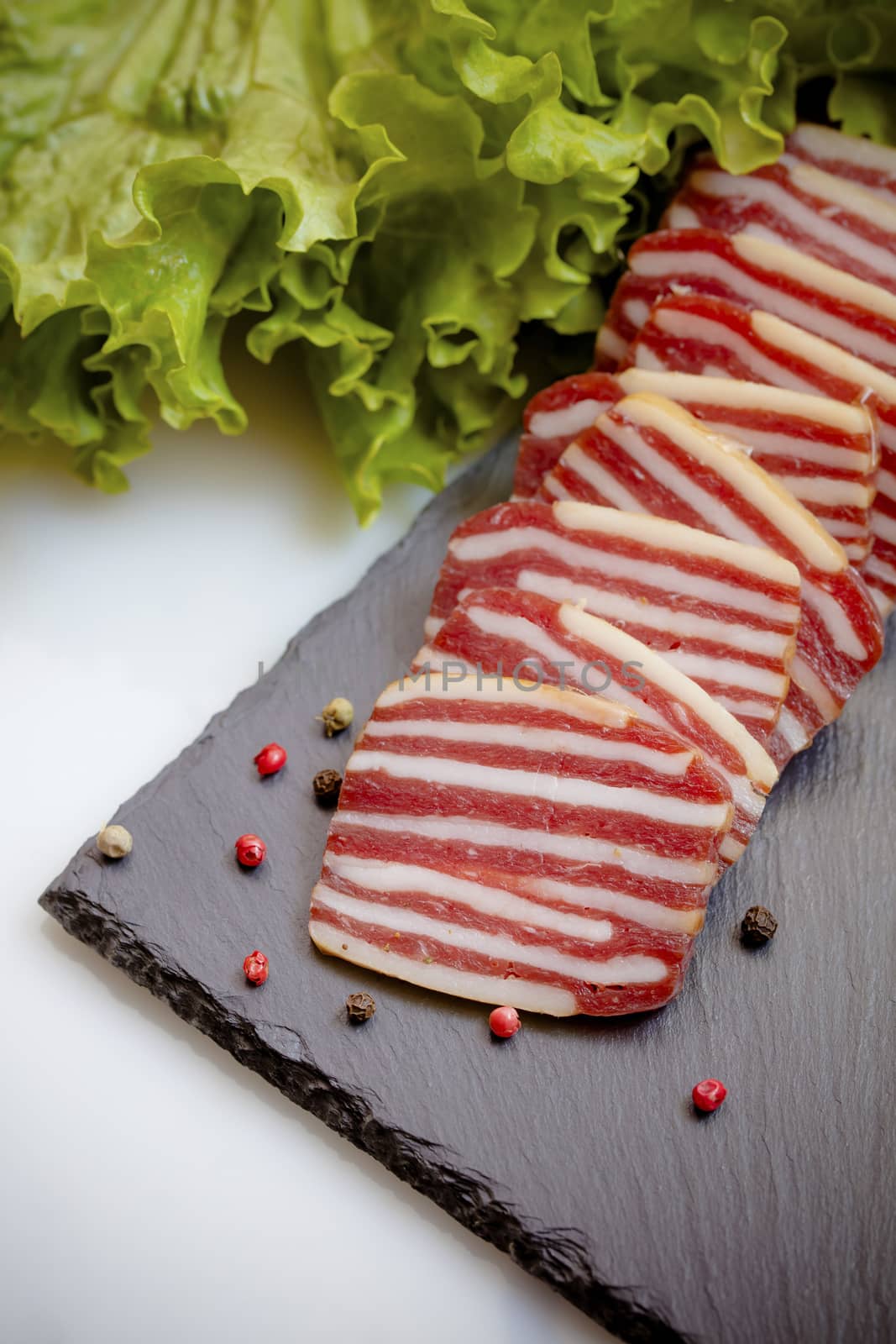 slices of sausage with lettuce and spices