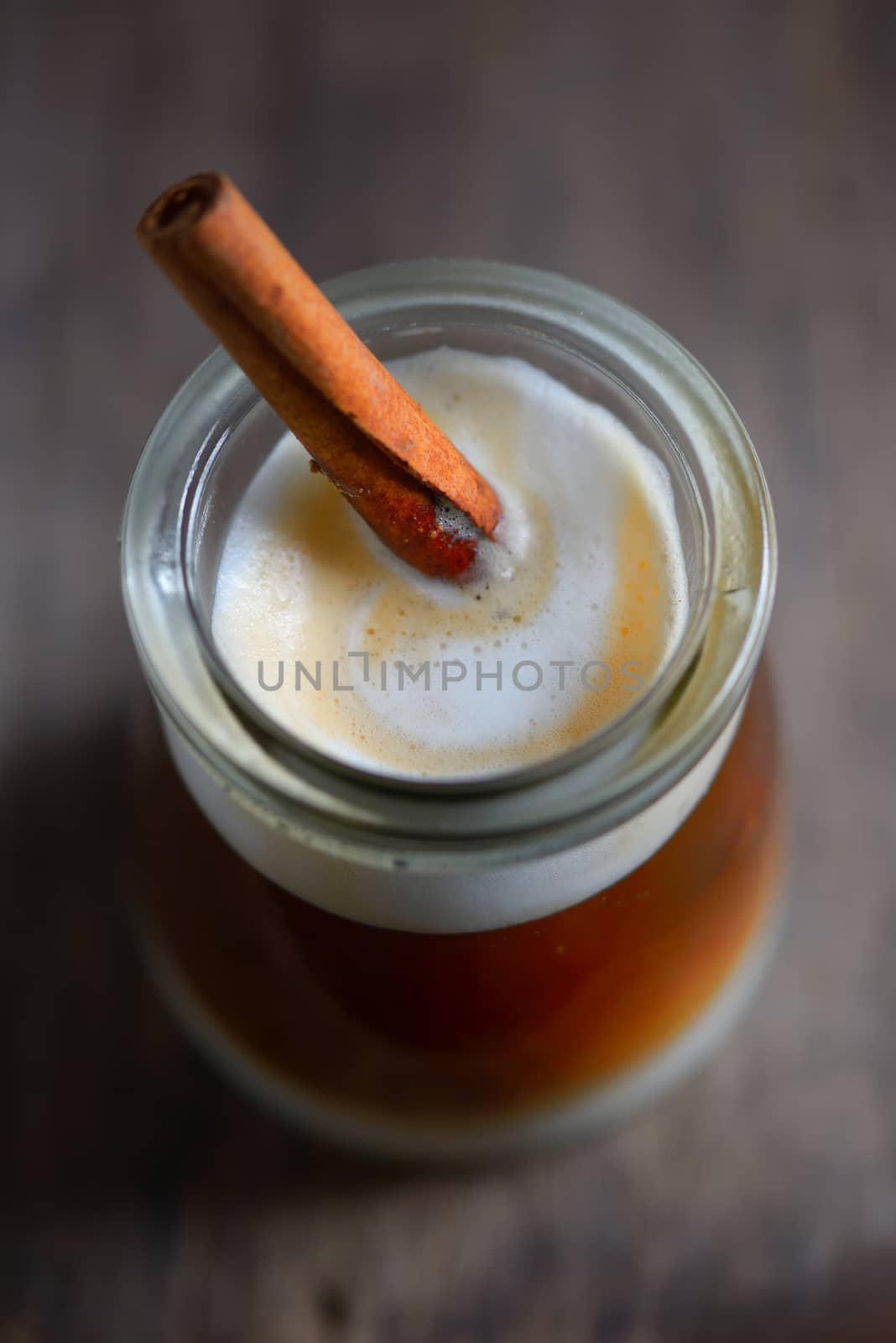 Cup of espresso and cinnamon stick on wooden table