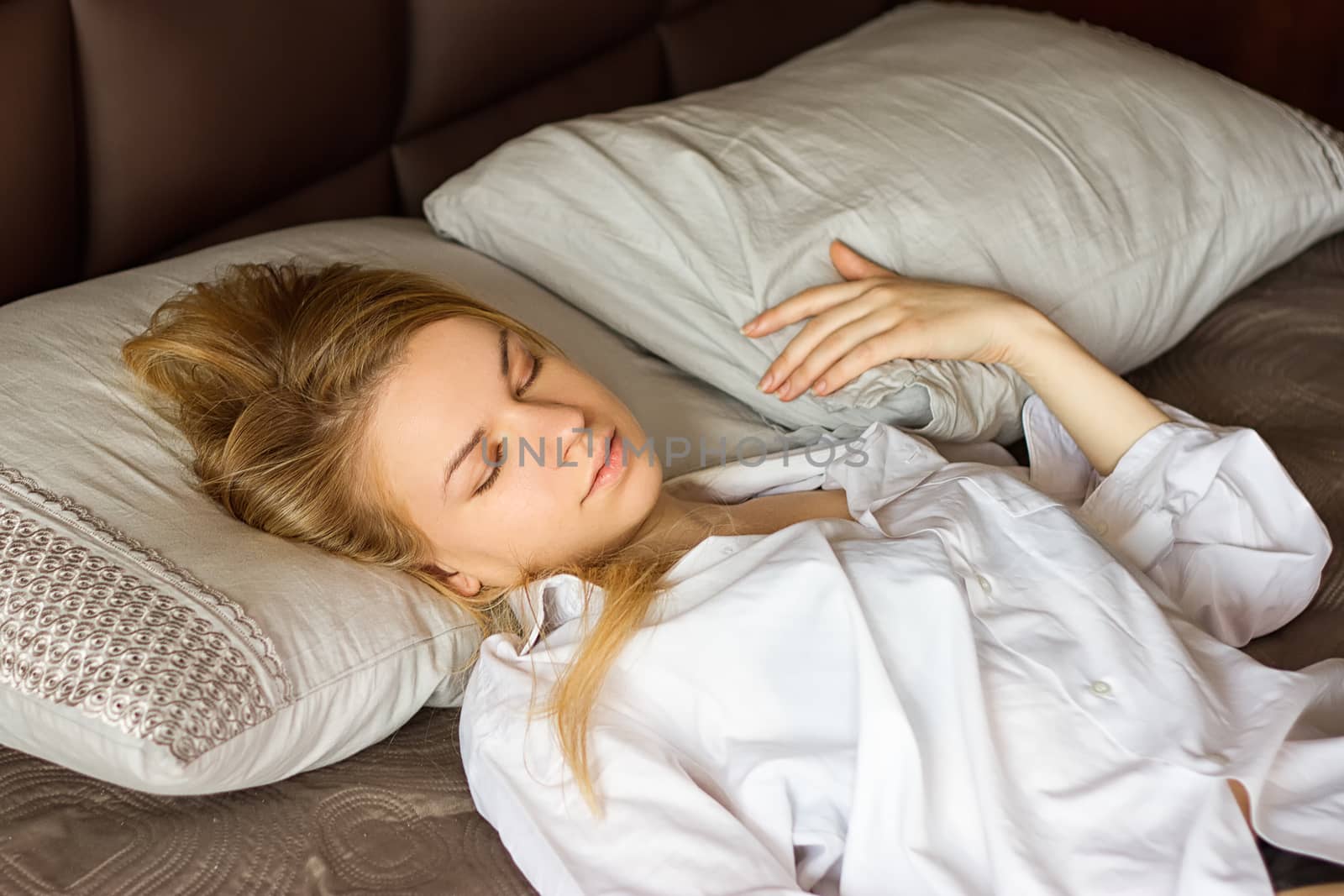 girl in a white men's shirt sleeping on the bed