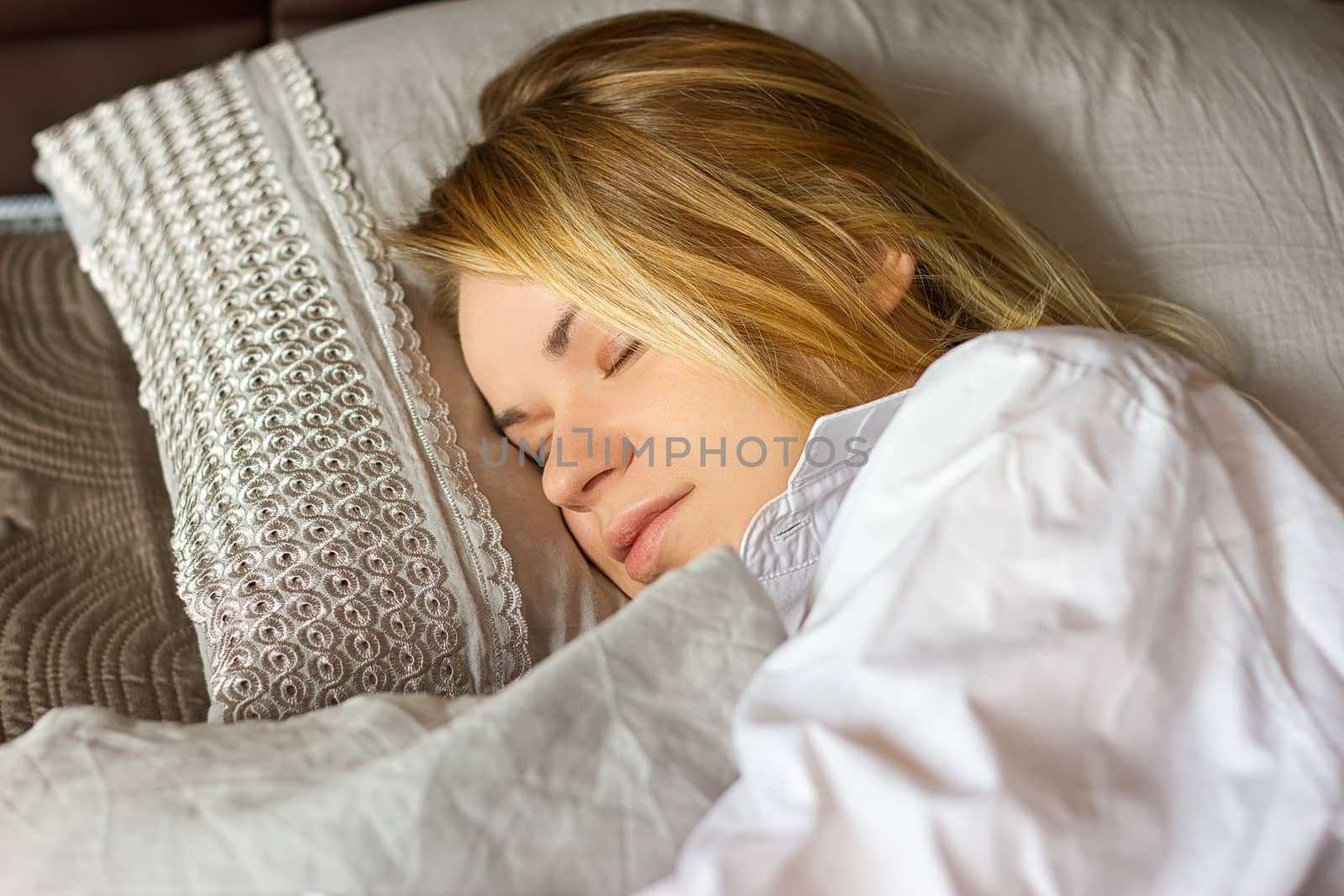 girl in a white men's shirt sleeping on the bed
