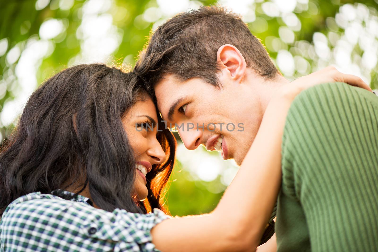 Close-up portrait of a young heterosexual couple in love to watch each other lovingly leaning their heads on each other.