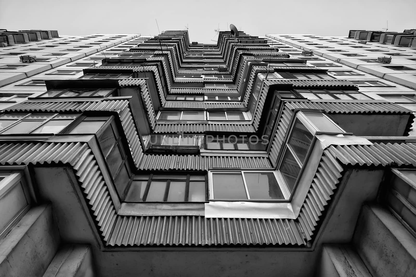 Modern apartment building. Front view. Divercity of windows.