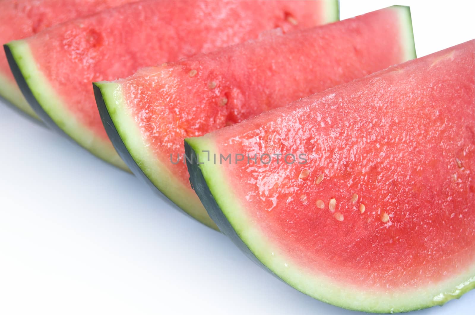 Whole watermelon fruit slices over a white background