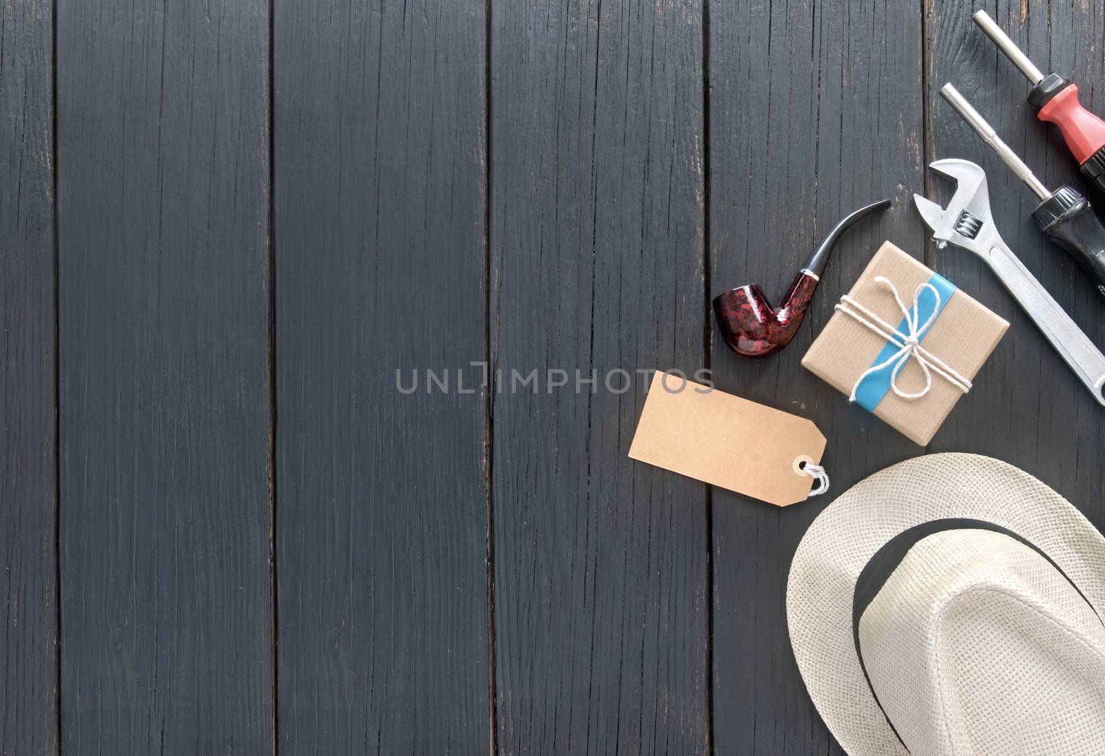 Fathers day gift box tied in blue ribbon over a wooden background with label