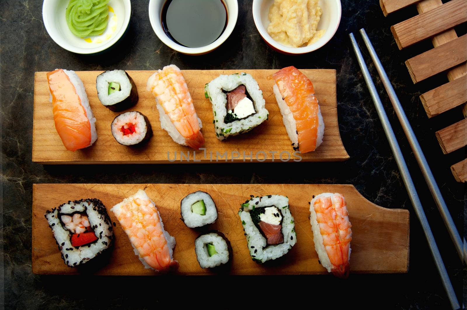 Selection of sushi including prawns, salmon and vegetables with rice on serving blocks