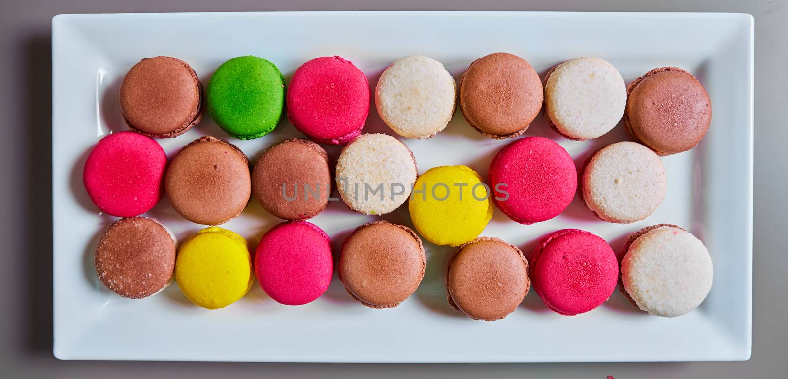 Colorful macaroons in white plate. Top view