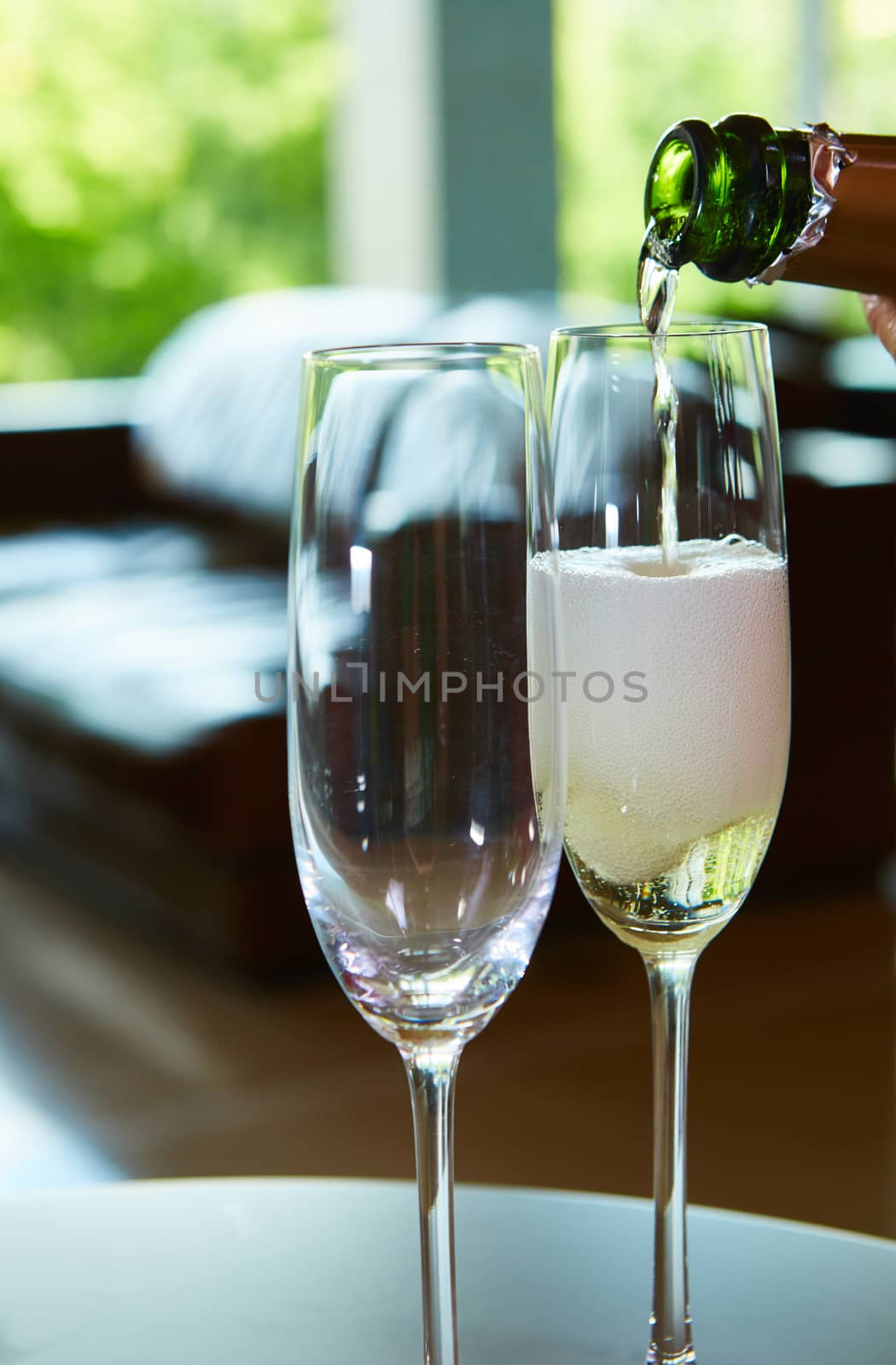 Champagne pouring in two elegant glasses. Closeup