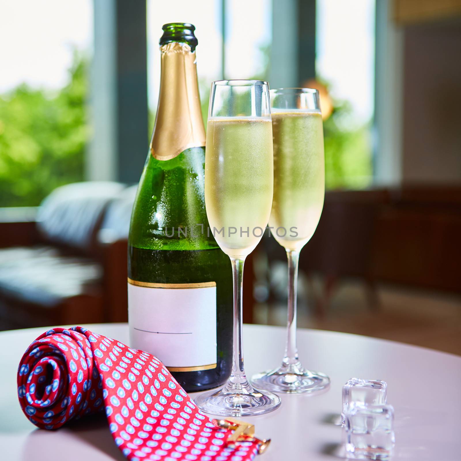 Two elegant champagne glasses on the background of green bottle. Festive still life.
