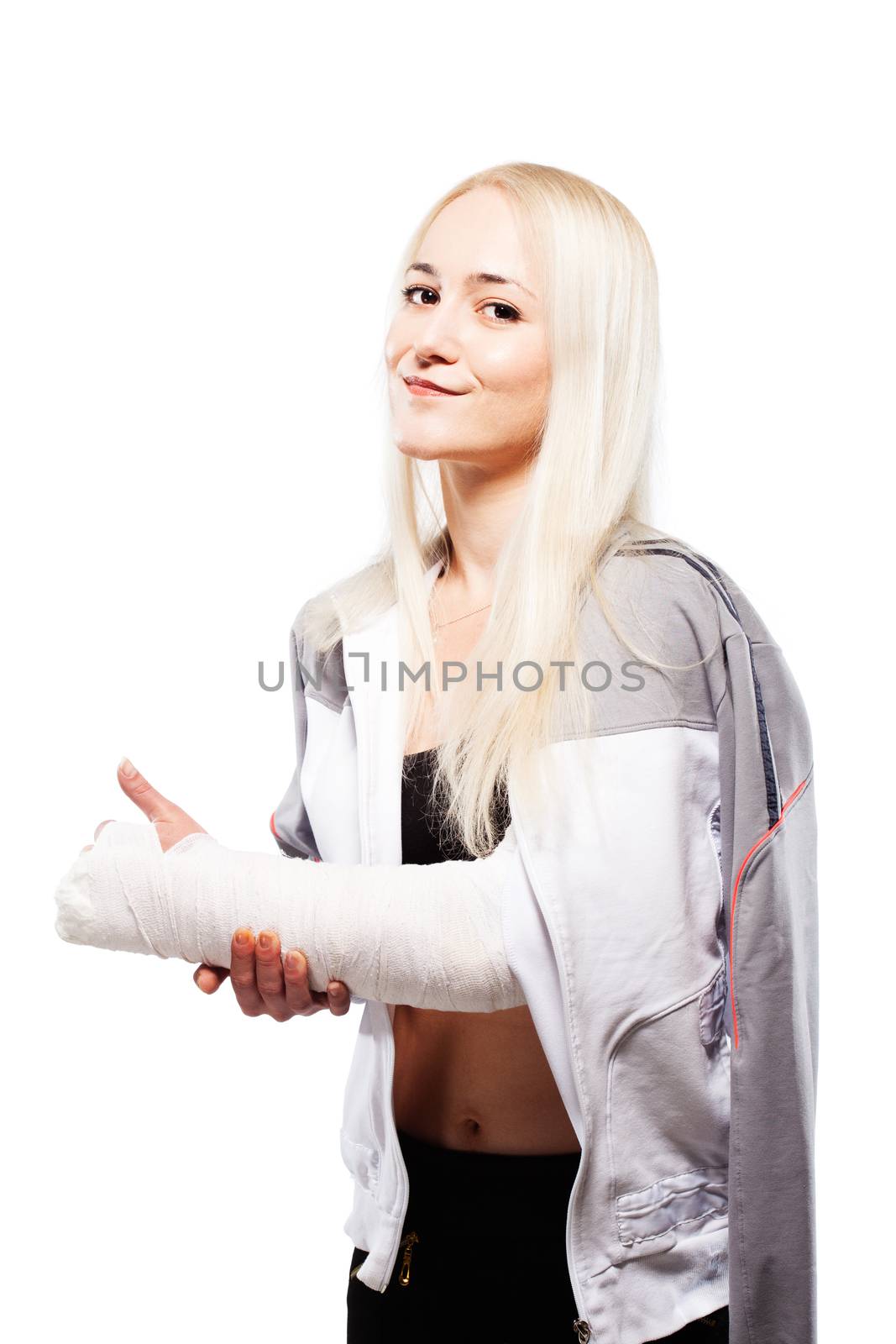 Fitness blond girl with a broken arm in plaster, sports outfit, making thumbs up gesture