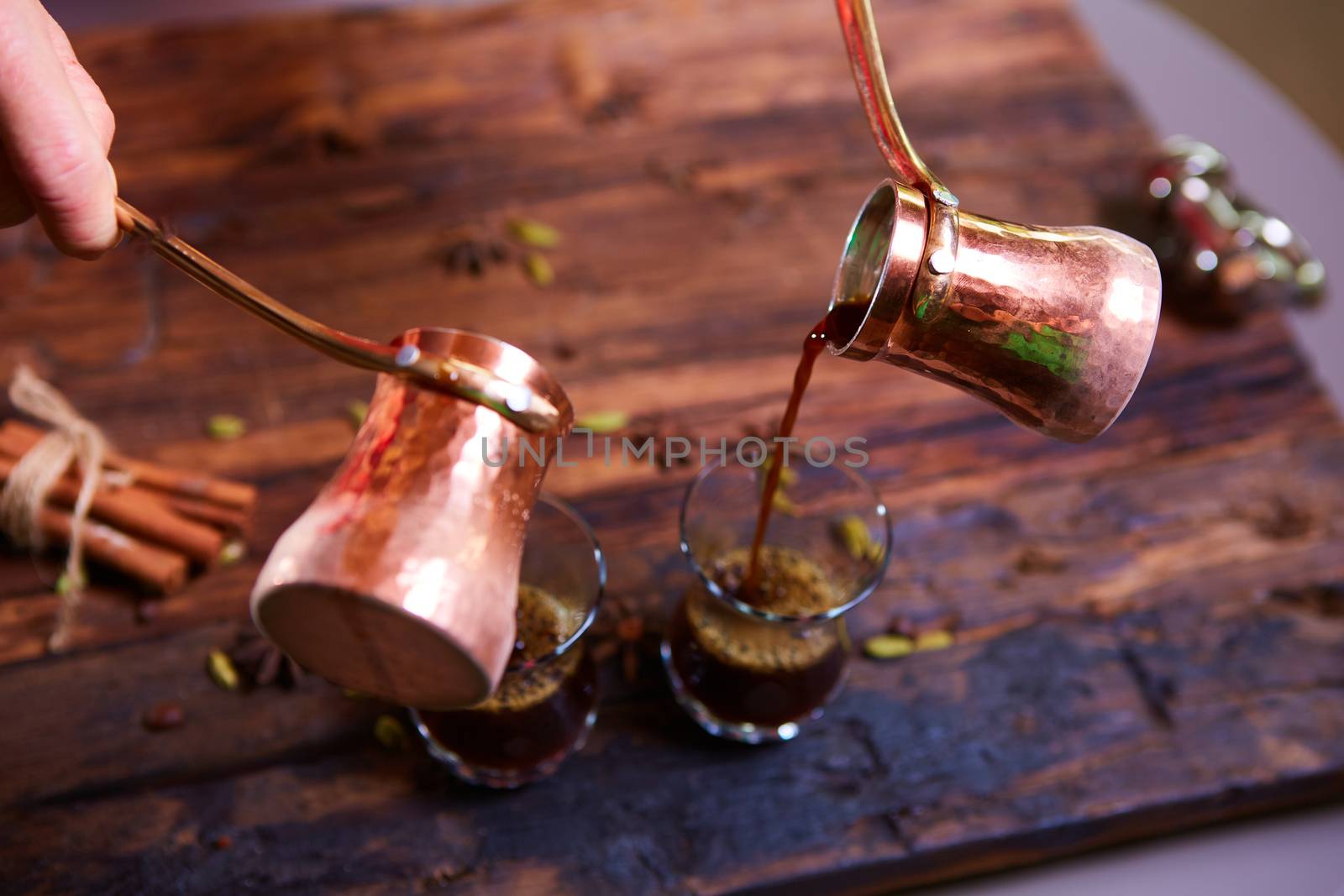 To pour arabic coffee in cups on wooden background. Glass cups