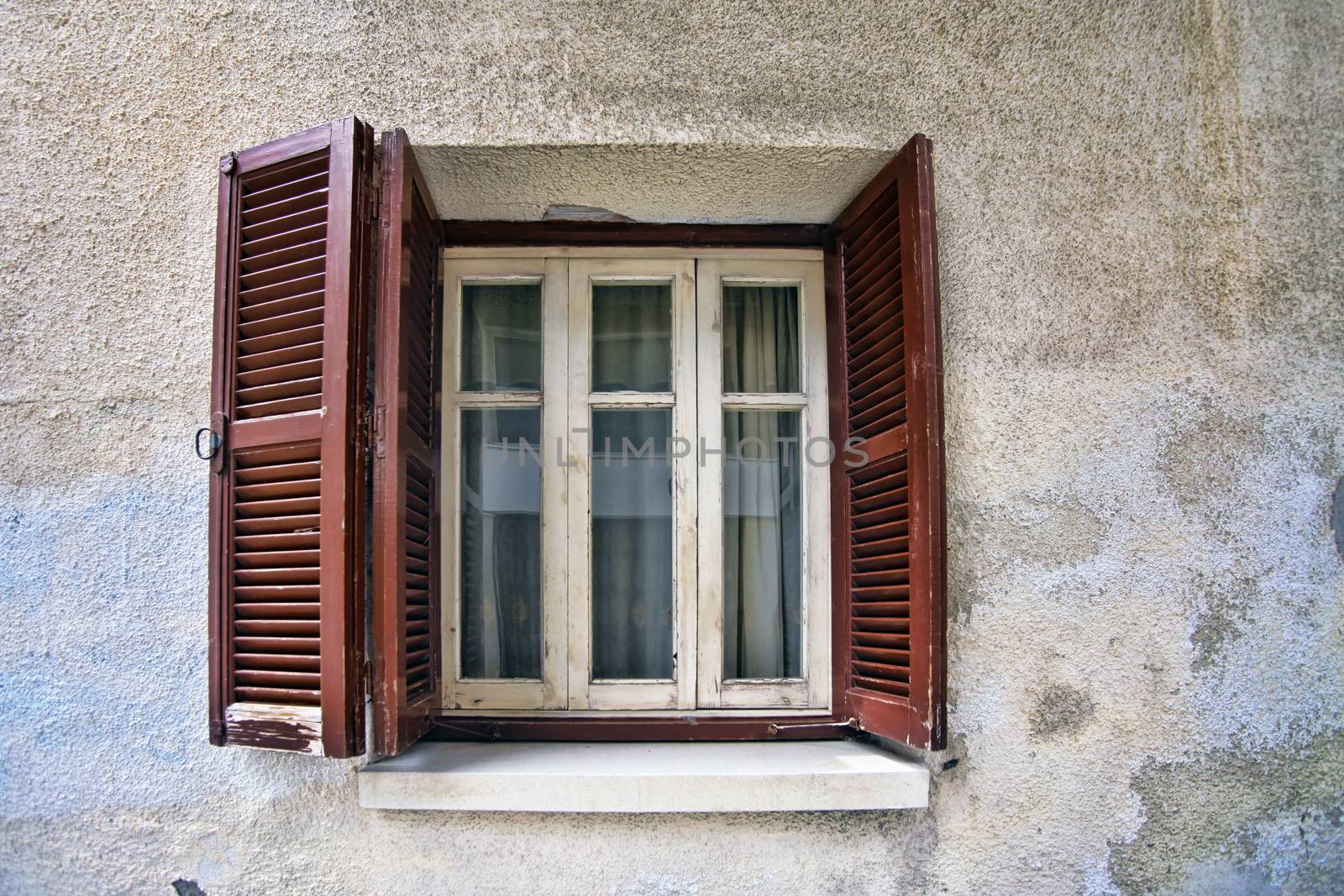 Old wooden window on stone wall