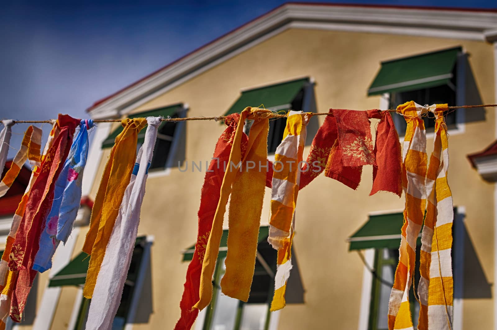 Colorful rags hanging on a cloth line with building in the background
