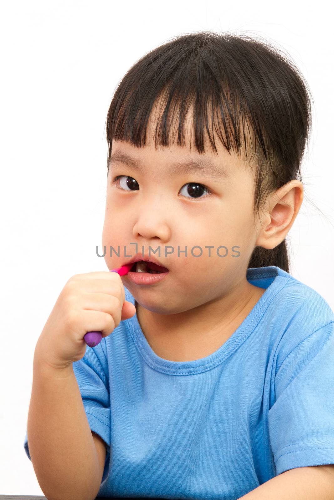 Chinese little girl brushing teeth in plain white isolated background.