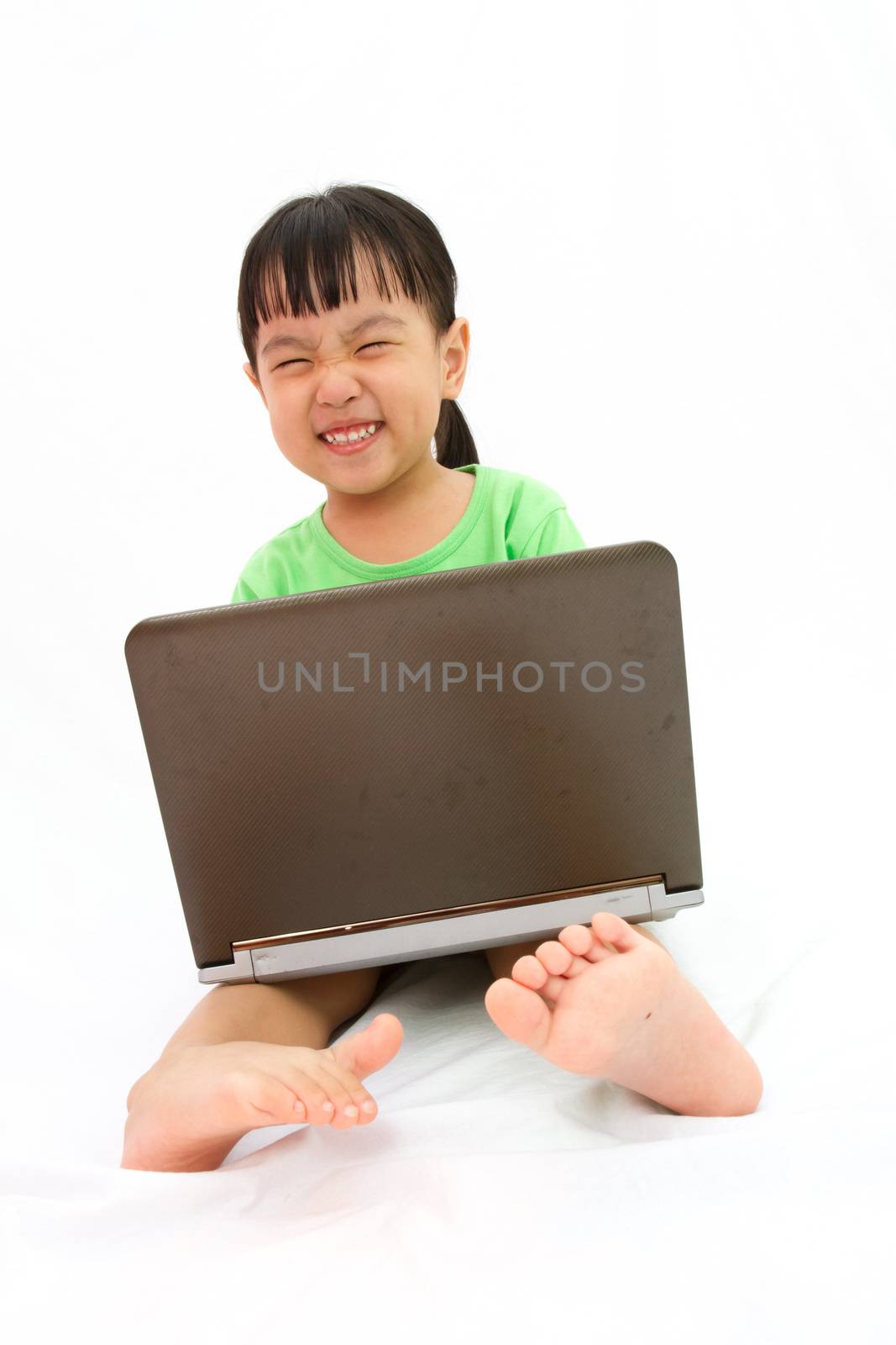 Chinese little girl sitting on floor with laptop by kiankhoon