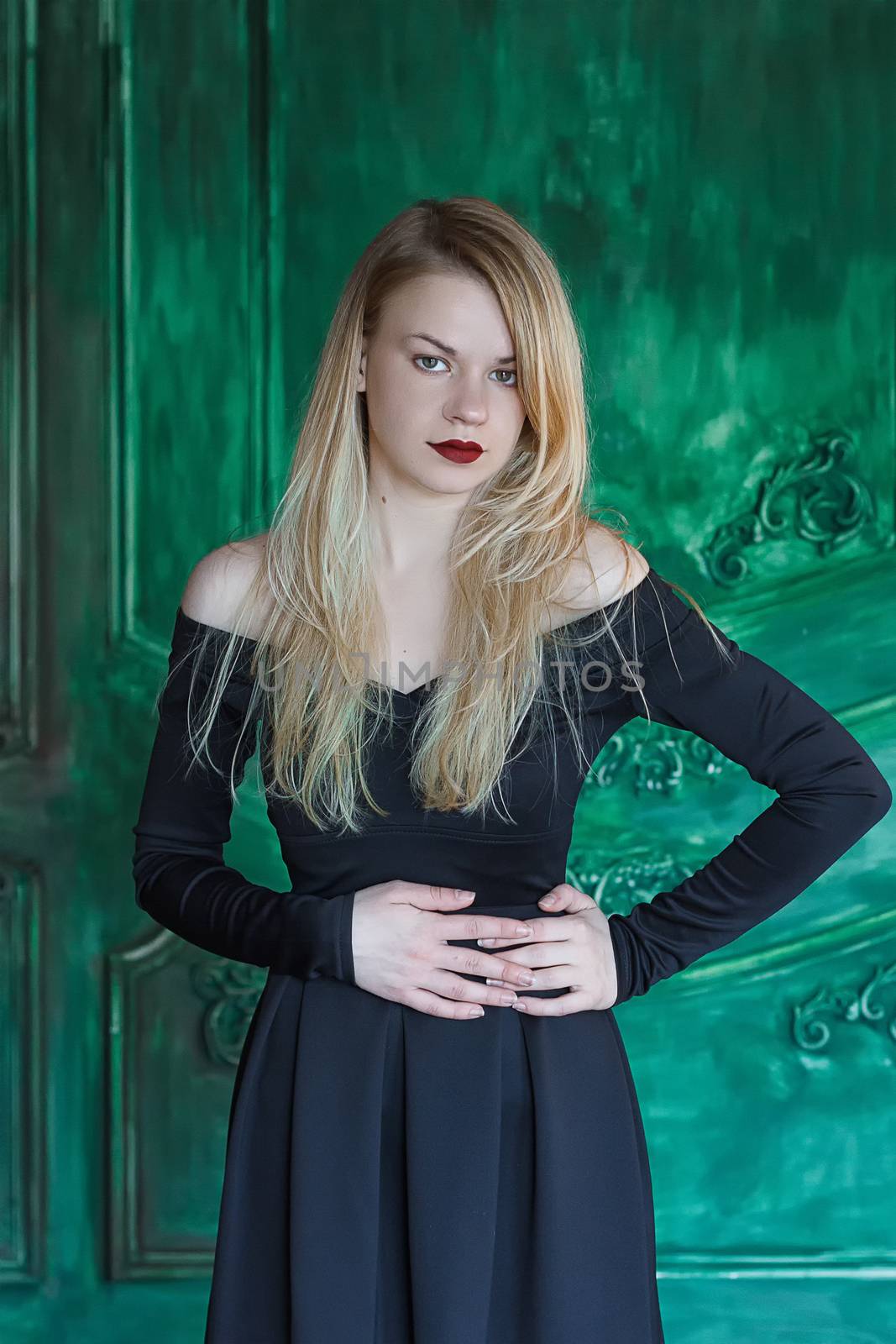 Elegant blonde in a black dress near grunge wall by victosha
