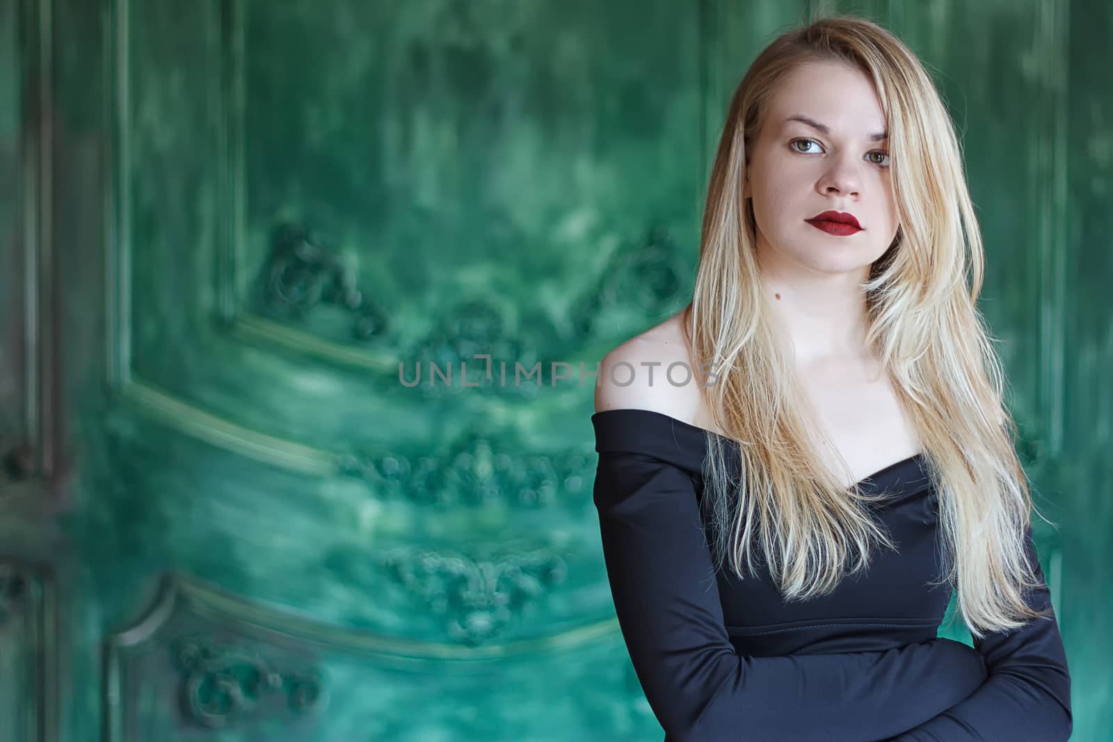 Elegant blonde in a black dress near grunge wall by victosha