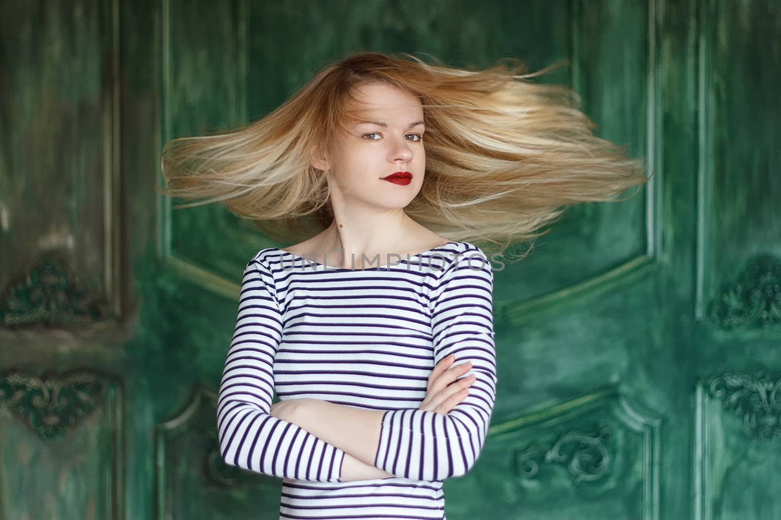 Blonde with red lips in striped shirt on a green background by victosha