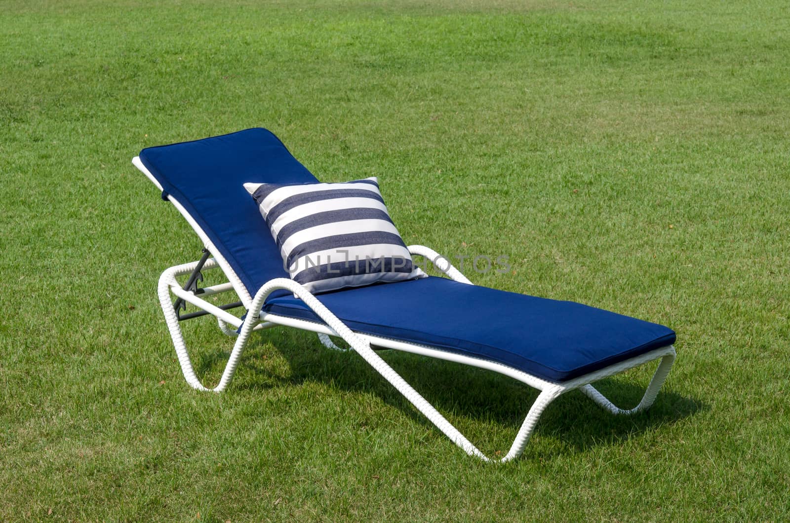 White rattan sun lounger and pillow in the garden