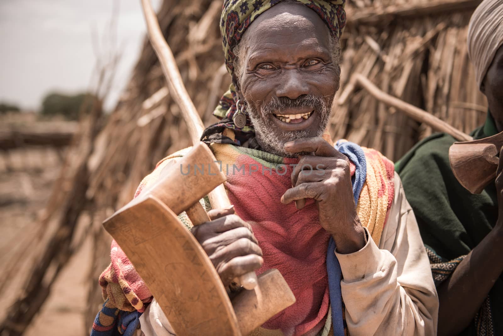 OMORATE, ETHIOPIA - 16 AUGUST 2015:  unidentified old man from Arbore tribe carry in his hands a traditional wooden chair, used also as a neckrest