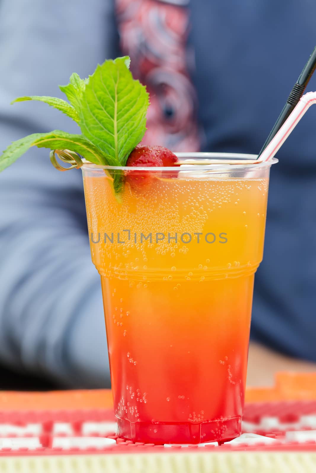 Cold cocktail with fruit pieces and air bubbles. Trade on the street.