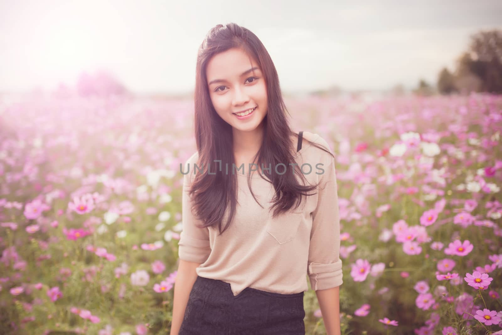 Beautiful asian women smiling in pink cosmos flower field by nopparats
