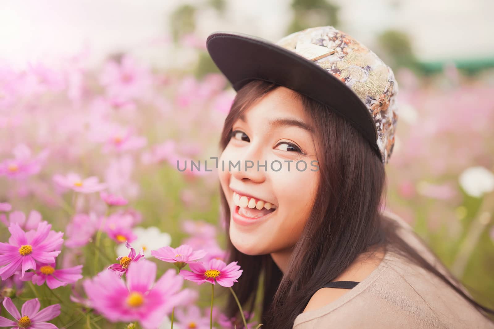 Beautiful asian women smiling in pink cosmos flower field by nopparats