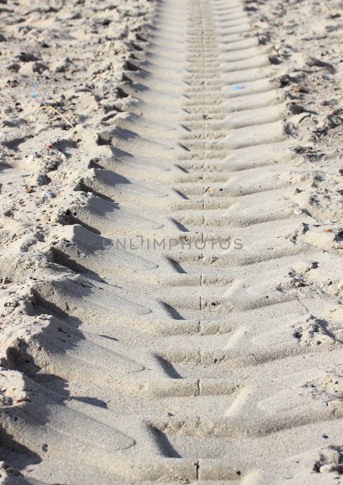 Heavy tractor track in dry beach sand in summer
