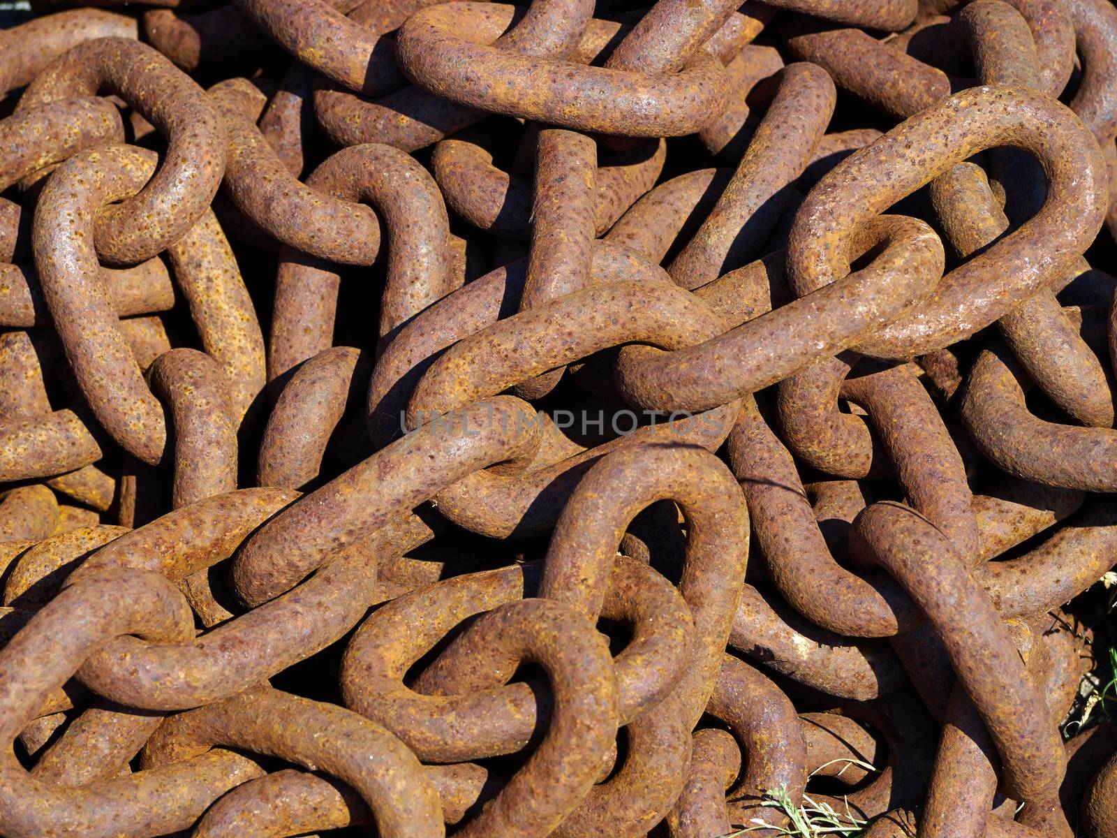 Old rusty metal iron chain on the ground in a port