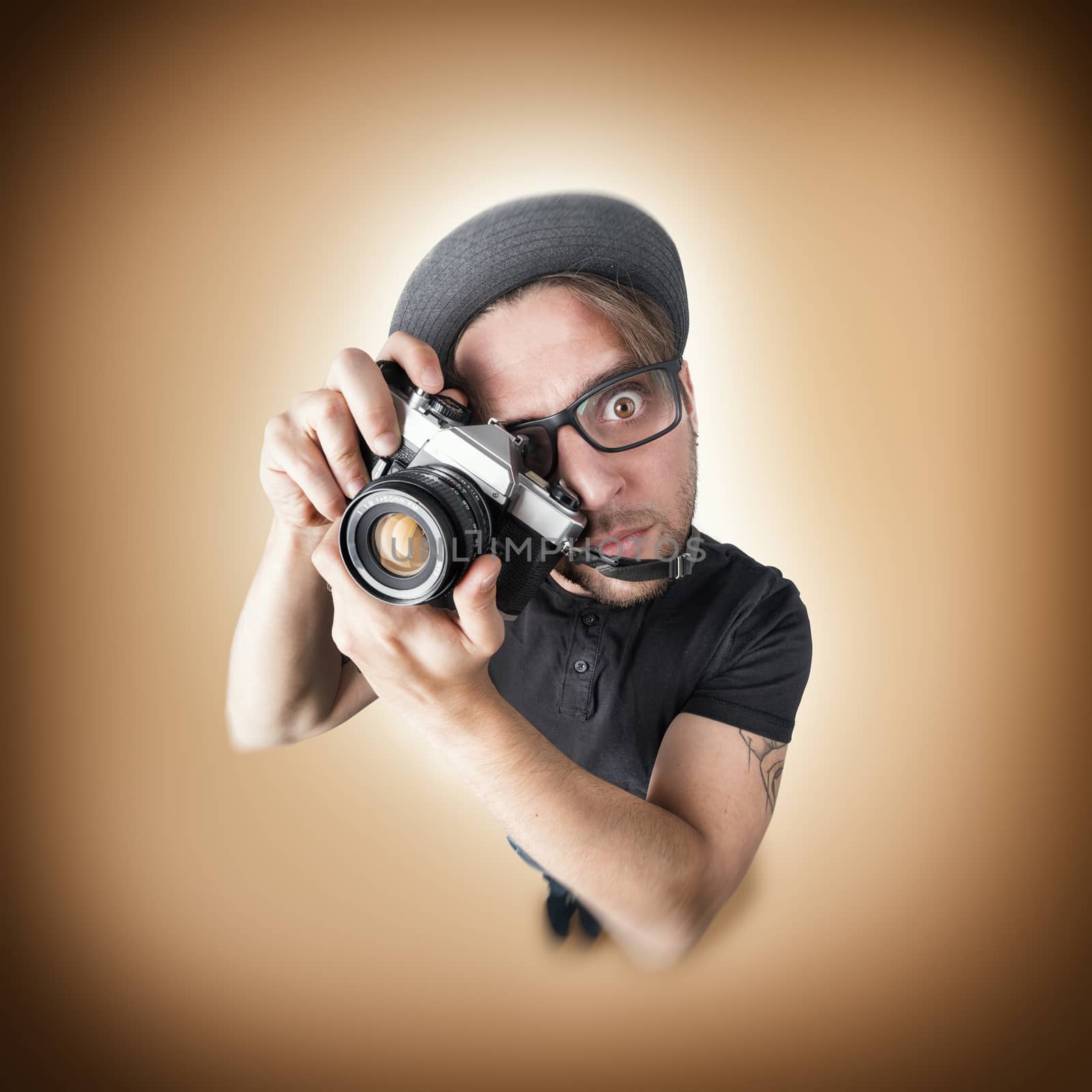 Funny man with a funny surprise expression shooting with his vintage reflex photo camera 