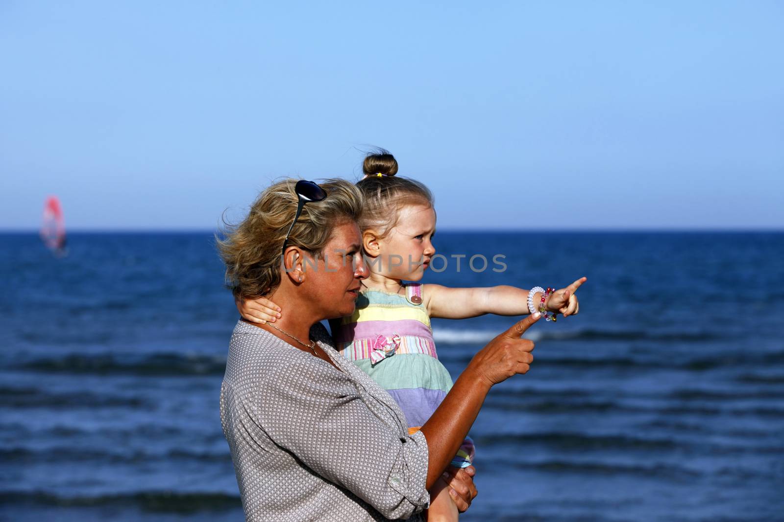 Grandmother with a little granddaughter on the beach