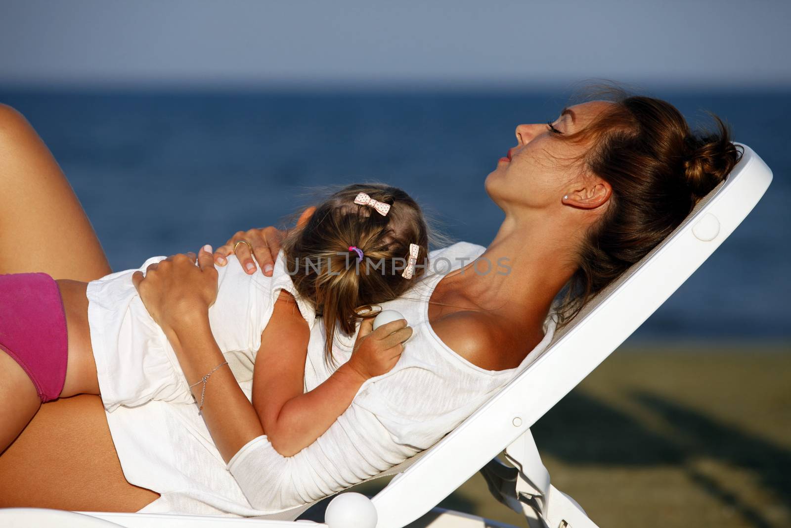 Happy mother holding her daughter on the beach