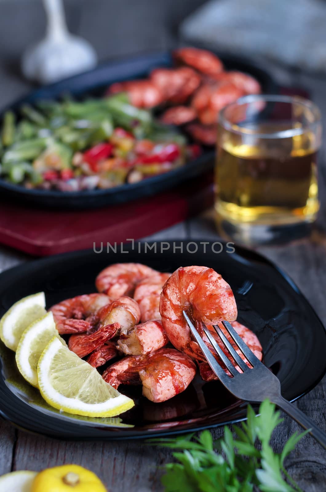 Grilled prawns with lemon, vegetables and beer. Rustic, low key and bokeh.