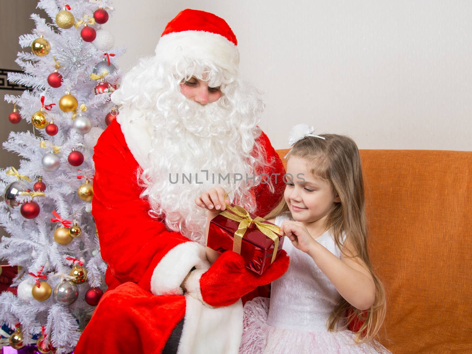 Girl unleashes a red ribbon gift that keeps Santa Claus in the hands of
