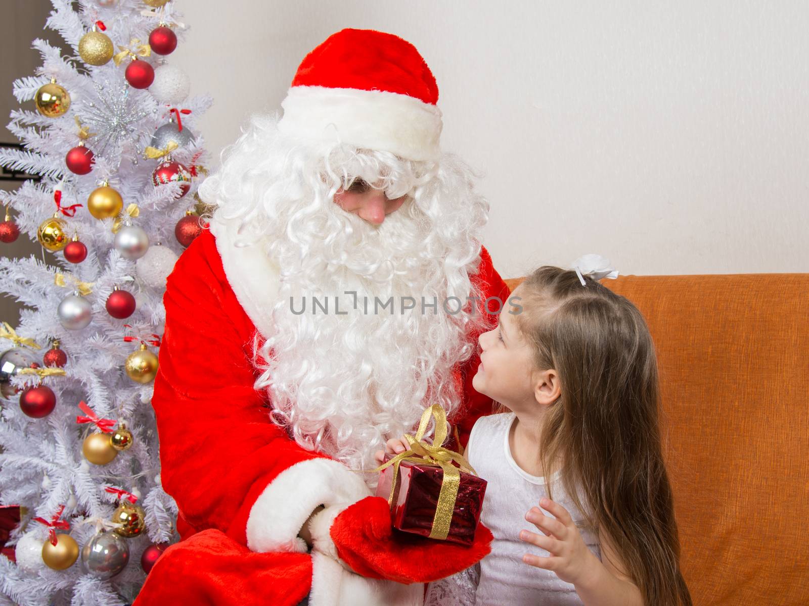 Santa Claus gives a gift a five-year girl
