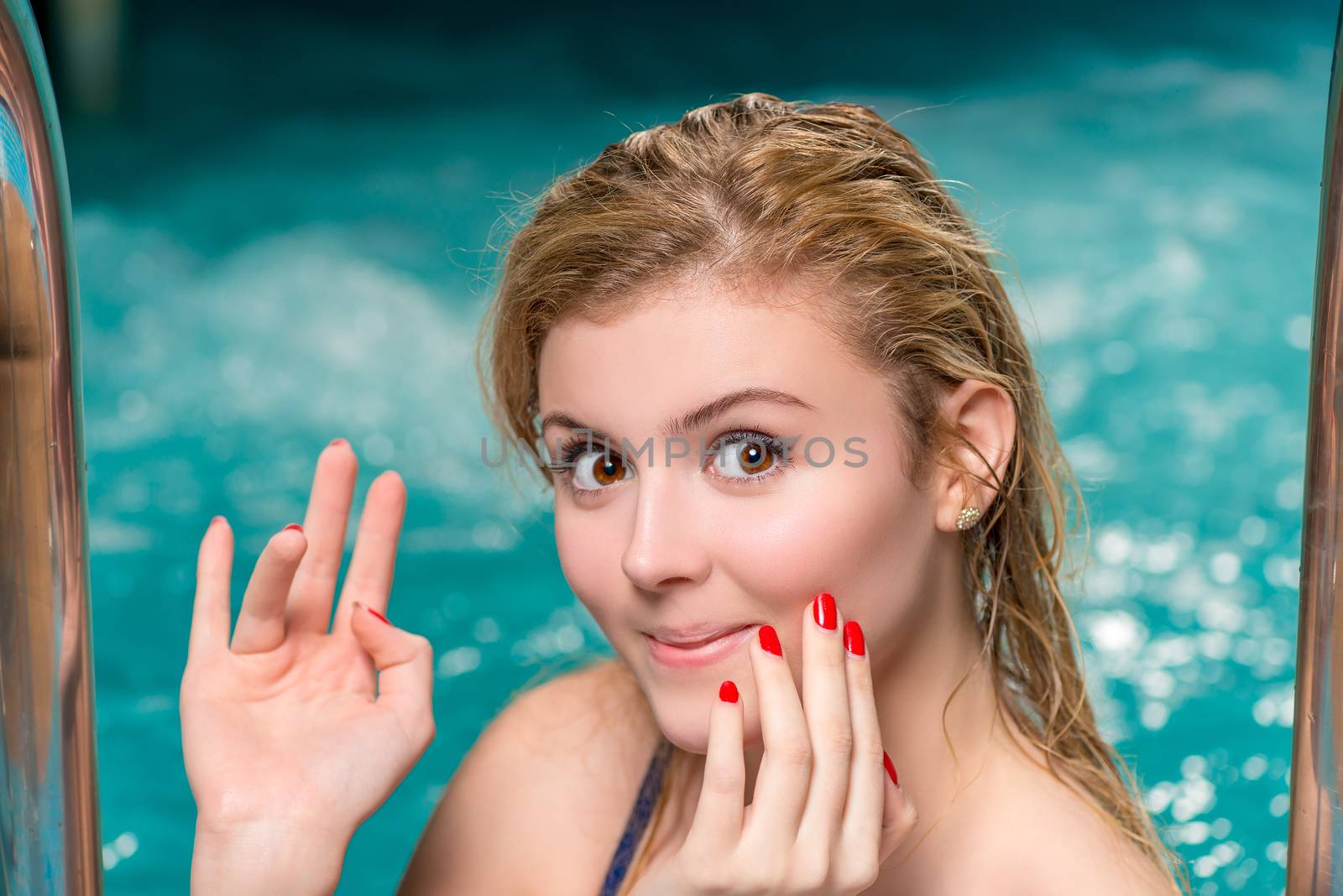 cute smiling girl posing in a swimming pool