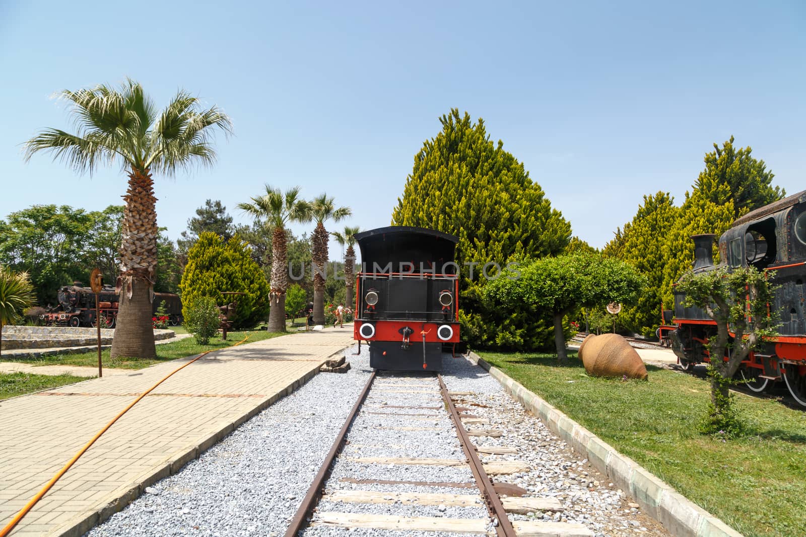 View of historical old rusty iron train locomotives, on blue sky background.