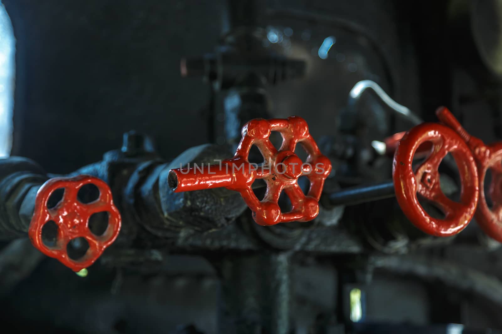 Close up detailed view of industrial iron valves and cables used in mechines.