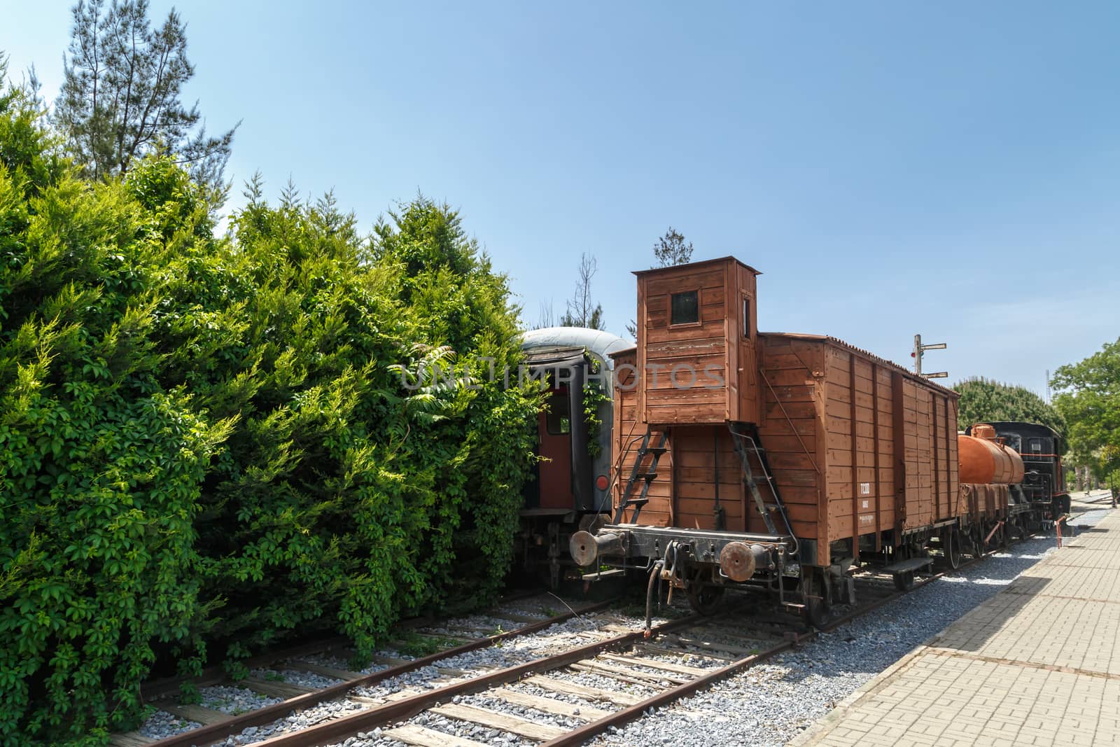 Close up detailed view of historical old rusty iron train locomotives, on blue sky background.