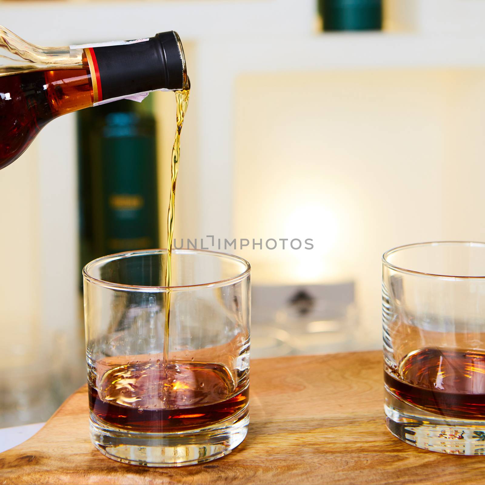 barman pouring whiskey in front of whiskey glass