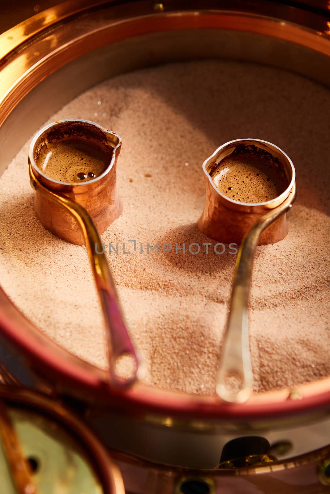 Preparation of Turkish coffee in the cezve in the sand at cafe bar by sarymsakov