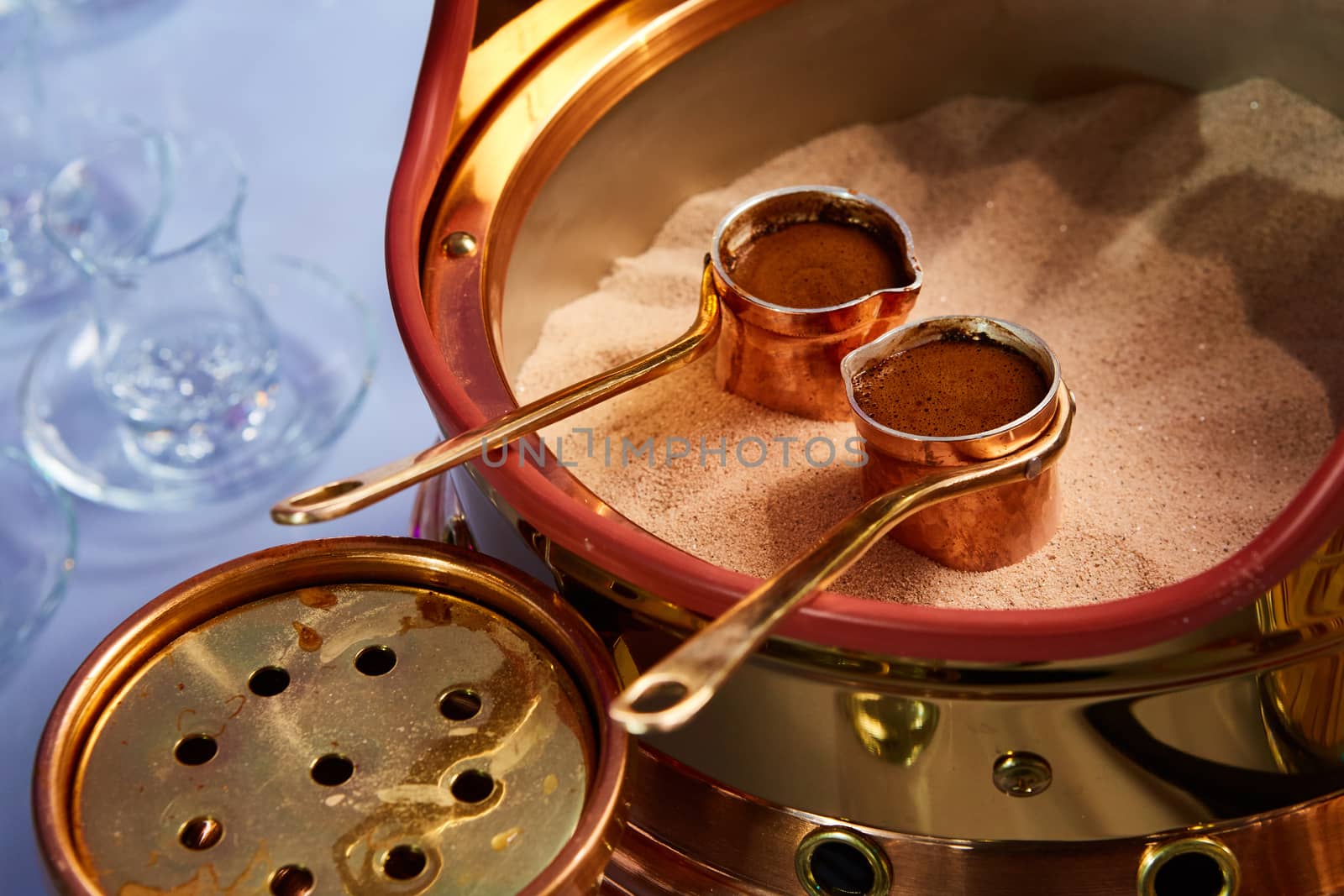 Preparation of Turkish coffee in the cezve in the sand at the cafe bar