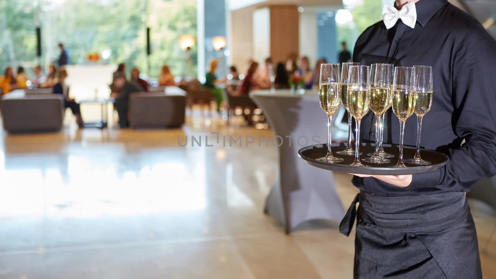 Waiter serving champagne glasses on a tray