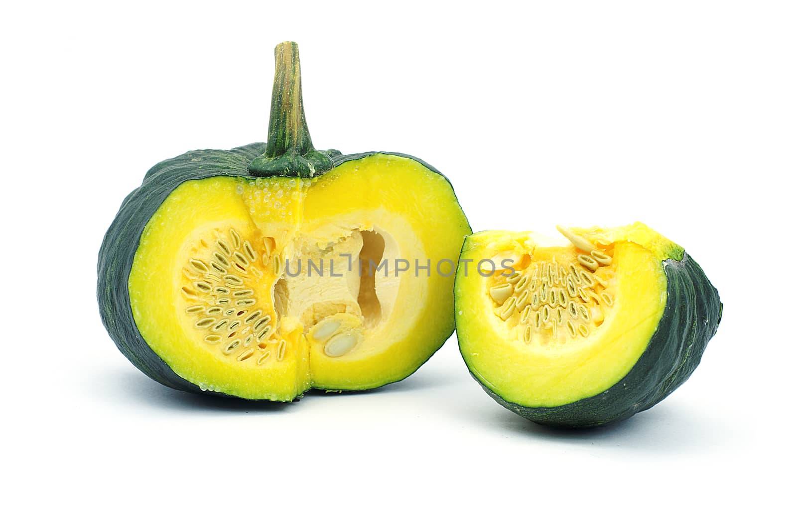 A yellow piece of pumpkin and green pumpkin on white background. A yellow sliced pumpkin and green pumkin on white background.