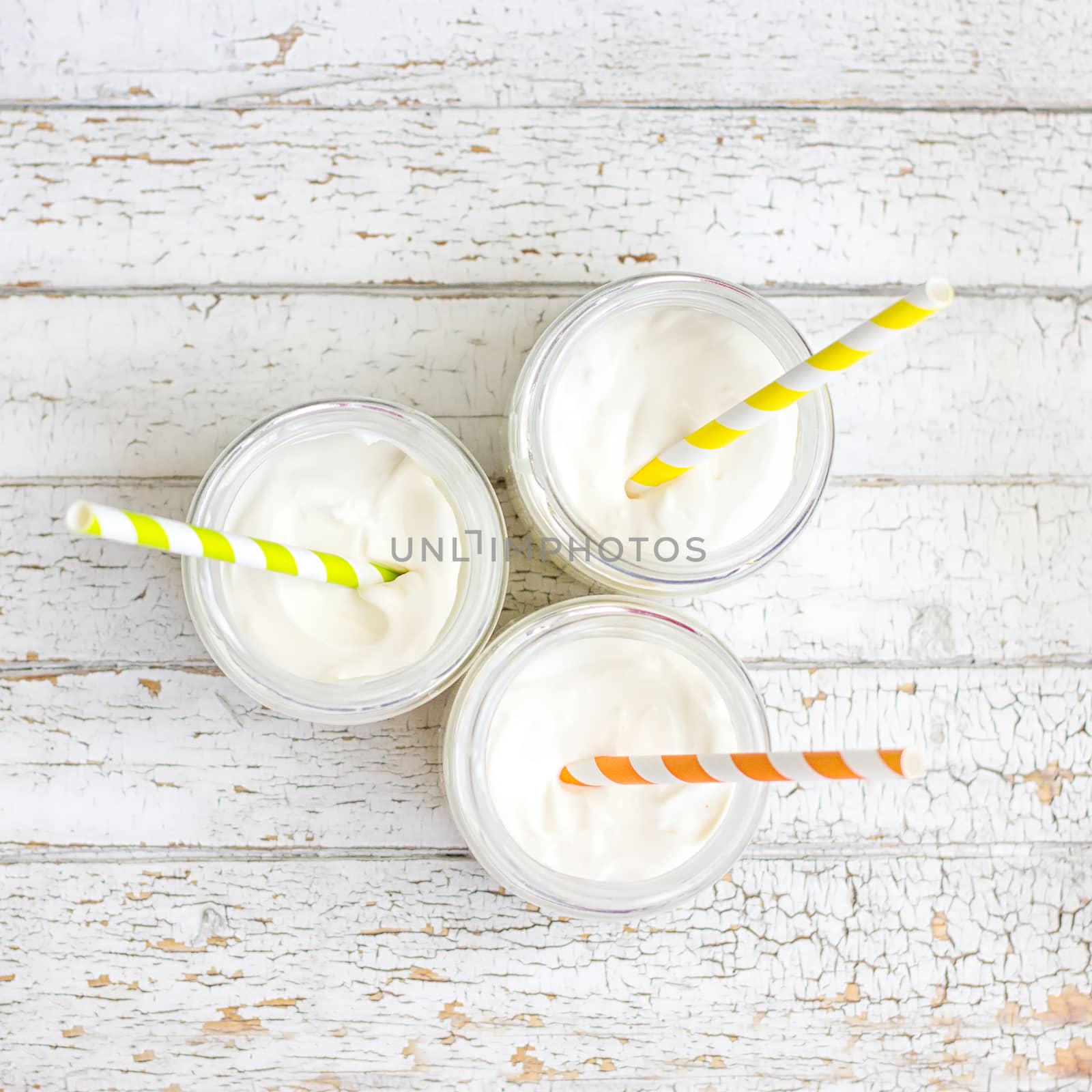 Yogurt in three small jars with straws by victosha