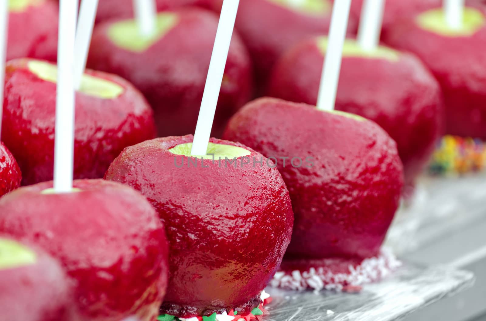 Fresh apples on a stick covered with red caramel ,on the market