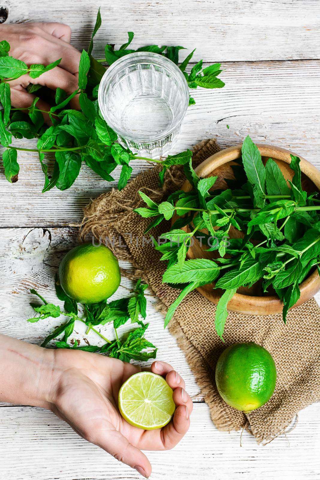 Hand with lime and preparing soft drink with water and lime