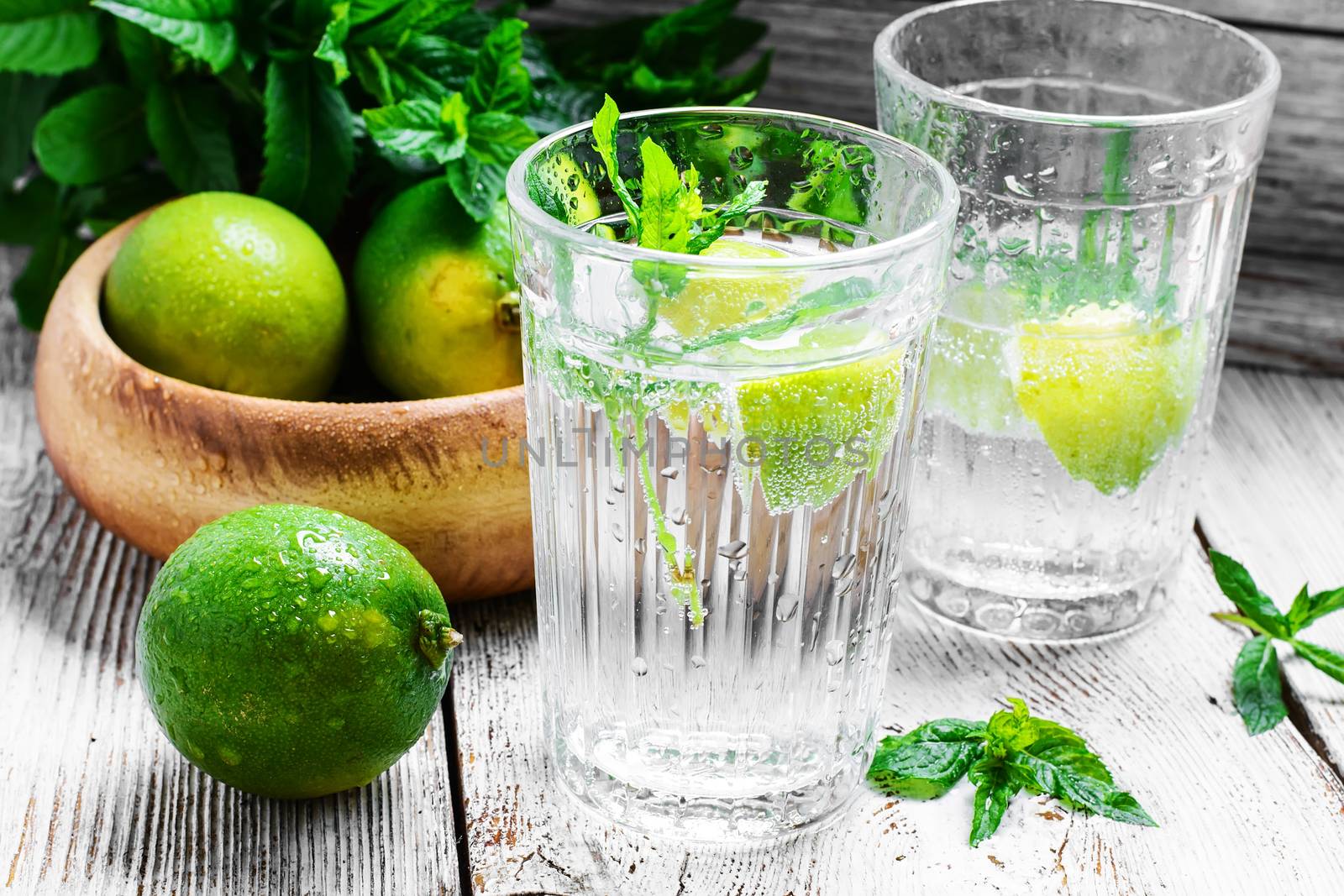 Two glasses with a cool drink of mineral water and lime