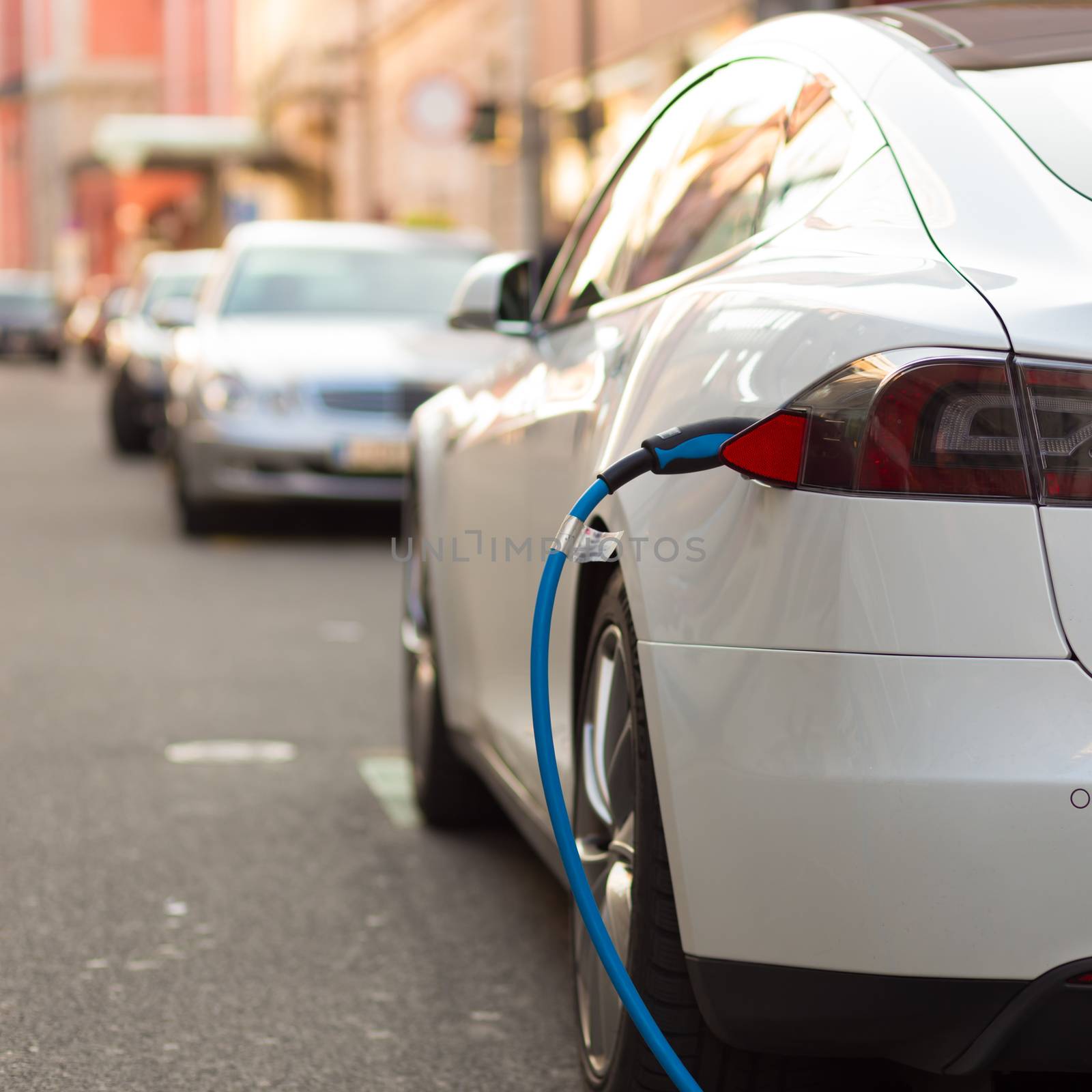 Power supply for electric car charging.  Electric car charging station. Close up of the power supply plugged into an electric car being charged.