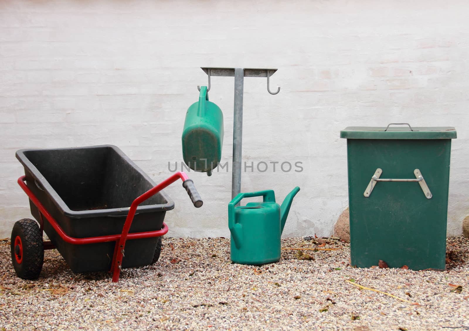 Green and black gardening tools at graveyard
