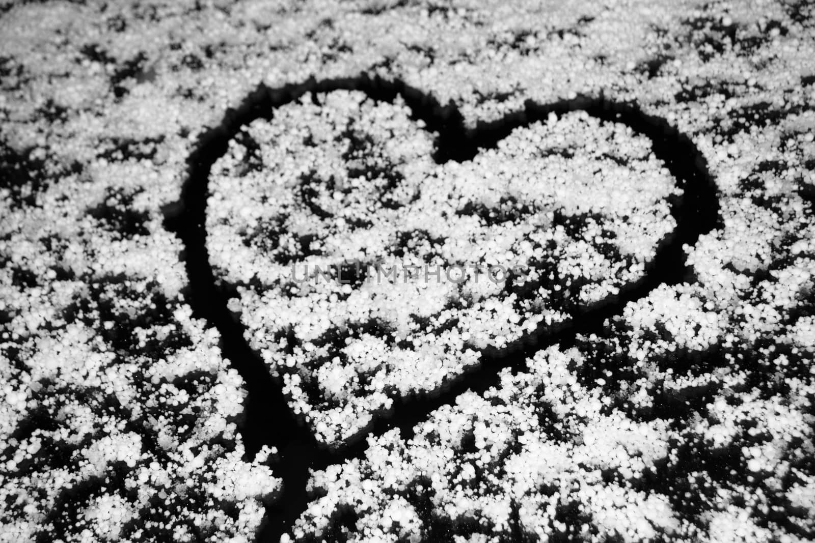 Heart drawing on windshield covered with hail